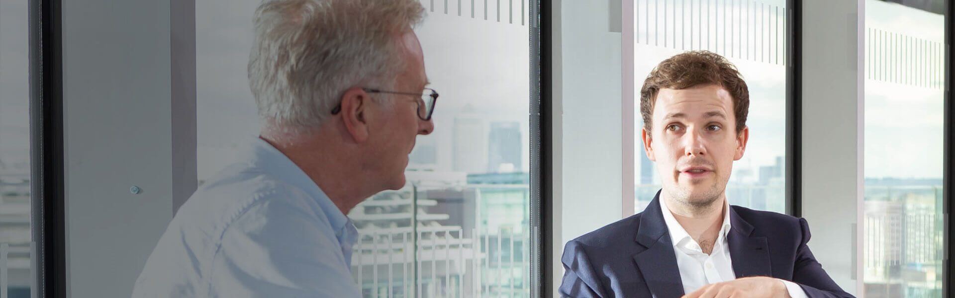 Image of two people chatting in a meeting room