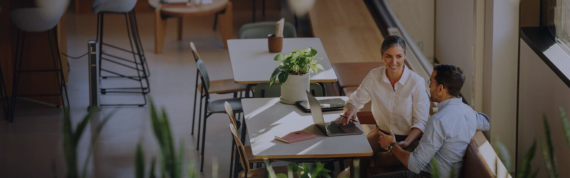 Image of two people sat t a table having an informal meeting